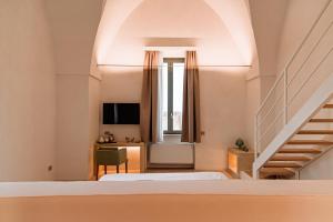 een slaapkamer met 2 bedden, een bureau en een trap bij Masseria Eirene in Lecce