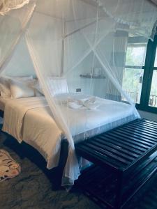 een slaapkamer met een hemelbed en een bank bij Turn View Resort Ella in Ella