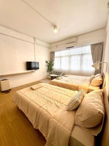 een slaapkamer met twee bedden en een flatscreen-tv bij Chatuchak Haus in Bangkok