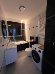 ein Badezimmer mit Waschmaschine in der Unterkunft Apartamenty Wilenska in Słupsk + 33 Fotos