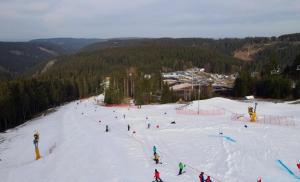 a group of people skiing down a snow covered slope at Ski Alm - Ferienunterkunft in Zella-Mehlis