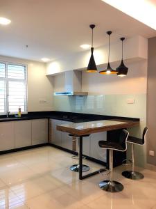 a kitchen with a wooden table and two chairs at Shamrock Boutique Villa in Batu Ferringhi