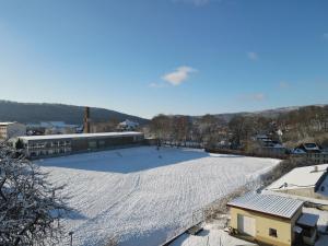 a large field covered in snow next to a building at Ski Alm - Ferienunterkunft in Zella-Mehlis +14 photos