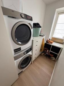a microwave and a washer and dryer in a room at 120 m2 newly renovated apartment in Copenhagen