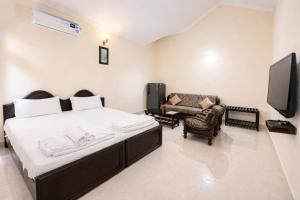 瓦加托杰克斯度假酒店的一间带床、沙发和电视的卧室