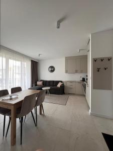 eine Küche und ein Wohnzimmer mit Tisch und Stühlen in der Unterkunft Apartamenty Wilenska in Słupsk