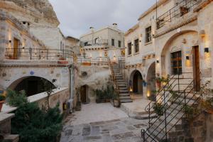 een oud gebouw met een trap op een binnenplaats bij Göreme Cave Suites in Goreme