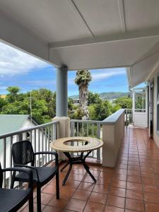 een terras met een tafel en stoelen op een balkon bij Sunny Side Apartment in Knysna