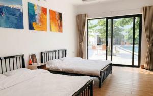 een slaapkamer met twee bedden en een groot raam bij Solmist Villa in Hòa Bình