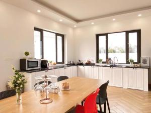 een keuken met een houten tafel en een keuken met ramen bij Solmist Villa in Hòa Bình