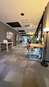 een leeg kantoor met een tafel en stoelen in een kamer bij 心斎橋難波関空直通 Ambers Hostel in Osaka +69 foto's