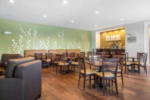een restaurant met stoelen en tafels in een ruimte bij Sleep Inn & Suites Marshall - University Area in Marshall
