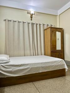 a bedroom with a bed with a curtain and a mirror at Sribhumi Homestay in Sreemangal +16 photos