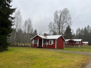 a red house in the middle of a field at Comfortable and cozy cottage in Sysslebäck