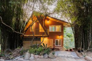 une maison avec un balcon au milieu des arbres dans l'établissement Baandin Chiewlarn, à Ban Tha Khun