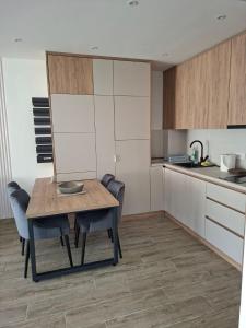 a kitchen with a wooden table and chairs in a room at Vidik jacuzzi apartment Divcibare in Divčibare