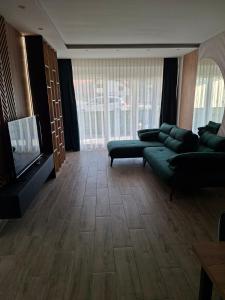 a living room with a couch and a flat screen tv at Vidik jacuzzi apartment Divcibare in Divčibare