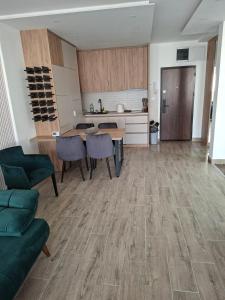 a kitchen with a table and chairs in a living room at Vidik jacuzzi apartment Divcibare in Divčibare +1 photo
