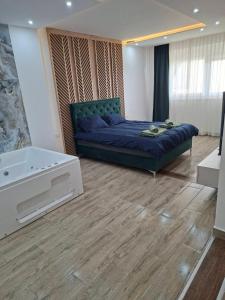 a bedroom with a blue bed and a bath tub at Vidik jacuzzi apartment Divcibare in Divčibare