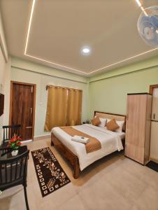 a bedroom with a large bed and a table at Kaizen Stay-Inn in Jowai