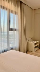 een slaapkamer met een bed en een groot raam bij Karim Hotel in Dammam
