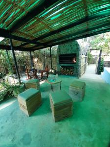 d'une terrasse avec une table, des tabourets et une cheminée. dans l'établissement Villa Olivia, à Riebeek-Kasteel