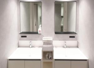 a bathroom with two sinks and two mirrors at The GAKUSUI in Hakuba