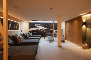 - un salon avec des canapés et une peinture murale dans l'établissement Hotel Garni Lavendel, à Lech am Arlberg