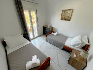 una camera da letto con due letti e una finestra di Livikon seaside a Keratokampos Altre 7 foto