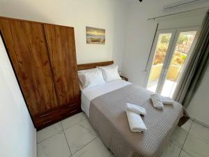 una camera da letto con un letto con due asciugamani sopra di Livikon seaside a Keratokampos