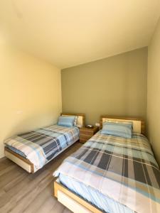 2 aparte bedden in een kamer met houten vloeren bij Haven46 