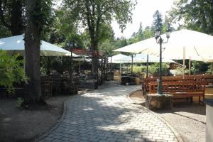 un parque con bancos, sombrillas y mesas en Gasthof Schönau, en Heilsbronn