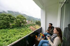 a man and a woman sitting in a room with a view at EKOSTAY - Amber Villa in Kodaikānāl +22 photos
