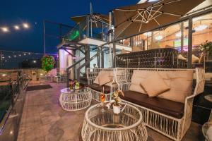 a patio with a couch and tables on a balcony at BluSalzz Residence Amritsar in Amritsar