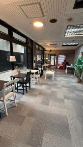 - un coin repas avec des tables et des chaises dans un bâtiment dans l'établissement 心斎橋難波関空直通Nambaminami Shin-Imamiya Ambers Hostel, à Osaka