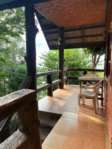 una veranda in legno con tavolo e sedia di Sea Rock Resort a Haad Pleayleam