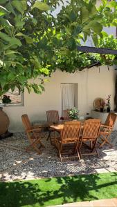 a patio with a table and chairs under a tree at El Corral de Tía Gloria in Pepino
