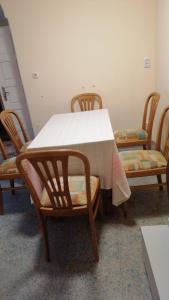 une table et des chaises avec des jupes de table et de chaises blanches dans l'établissement Апартамент опера, à Varna