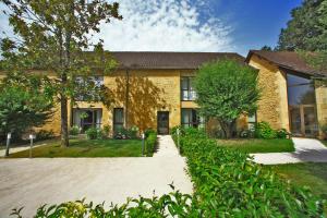 a brick house with a driveway in front of it at Les Jardins du Porche in Sarlat-la-Canéda