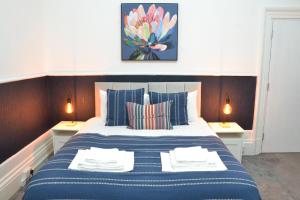 - une chambre avec un lit bleu et blanc et 2 lampes dans l'établissement Manchester Ashton Suites, à Ashton-under-Lyne