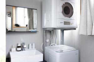 ein Badezimmer mit Waschbecken und Waschmaschine in der Unterkunft ROTAN東本町 Omura in Matsue
