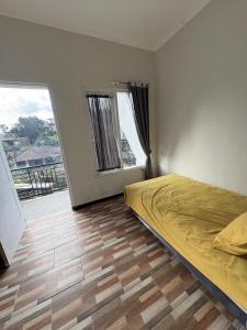 ein Schlafzimmer mit einem Bett und einem großen Fenster in der Unterkunft Prabu Villa in Batu