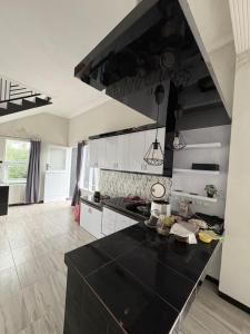 eine große Küche mit einer schwarzen Arbeitsplatte in der Unterkunft Prabu Villa in Batu