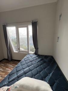 ein Schlafzimmer mit einem Bett mit einem großen Fenster in der Unterkunft Prabu Villa in Batu + 3 Fotos