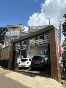 ein Gebäude mit zwei Autos in einer Garage in der Unterkunft Prabu Villa in Batu