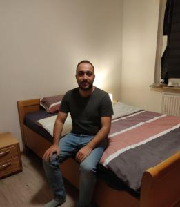 un homme assis sur un lit dans l'établissement Doppelbett, à Dinslaken