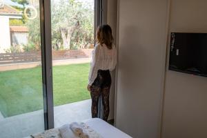 a woman standing in a room looking out the window at Villa Giuseppe Seaside in Lido Di Fondi