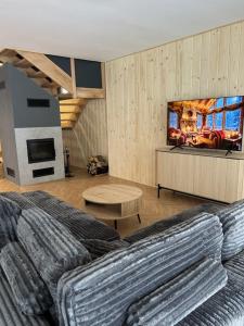 een slaapkamer met een groot bed en een tv bij Biołe Izby in Poronin