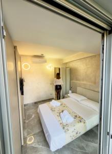 ein Schlafzimmer mit zwei Betten und einer Frau, die im Spiegel steht in der Unterkunft Villa Giuseppe Seaside in Lido Di Fondi