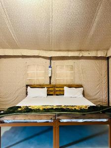 Bett in einem Zelt mit zwei Kissen in der Unterkunft Stayguru Patgar Tent in Dhordo